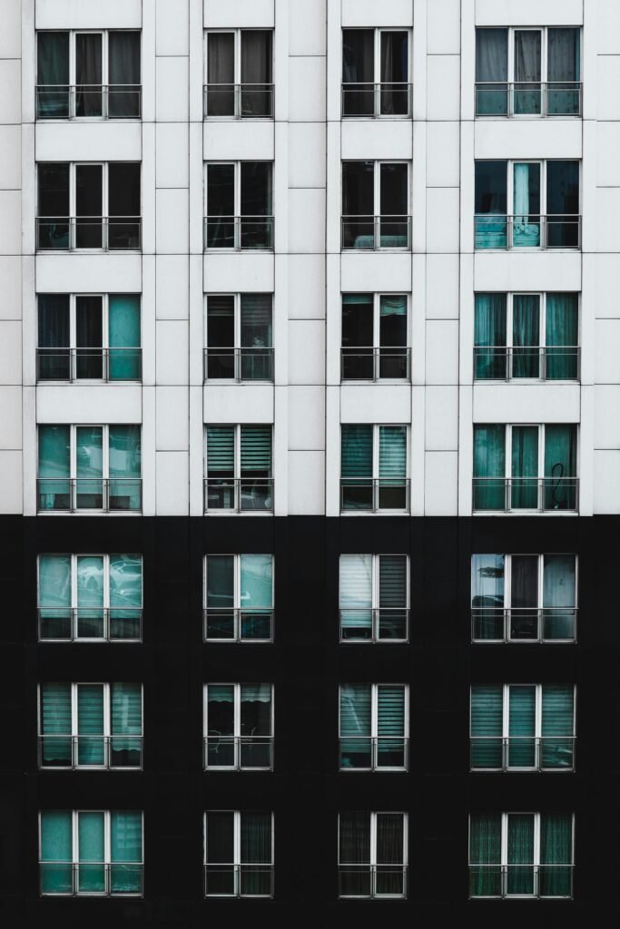 Close-up of a modern residential building with contrasting black and white facade and multiple windows.